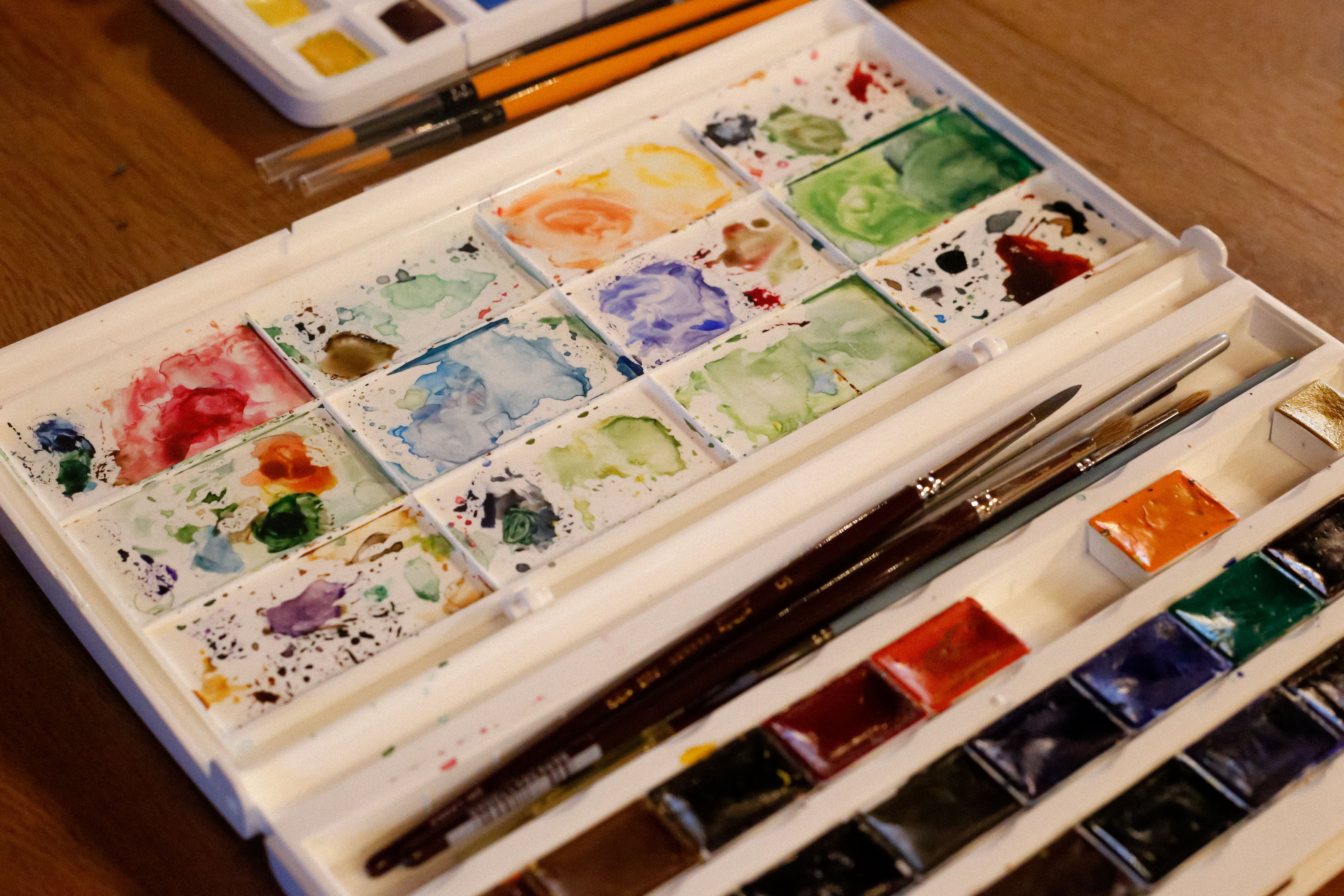 Close-up of a watercolor palette with paintbrushes