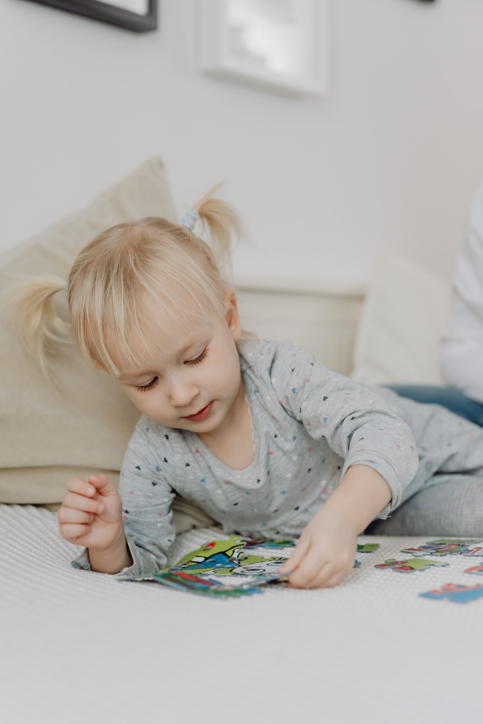 A toddler working on a puzzle, focused on fitting the pieces together